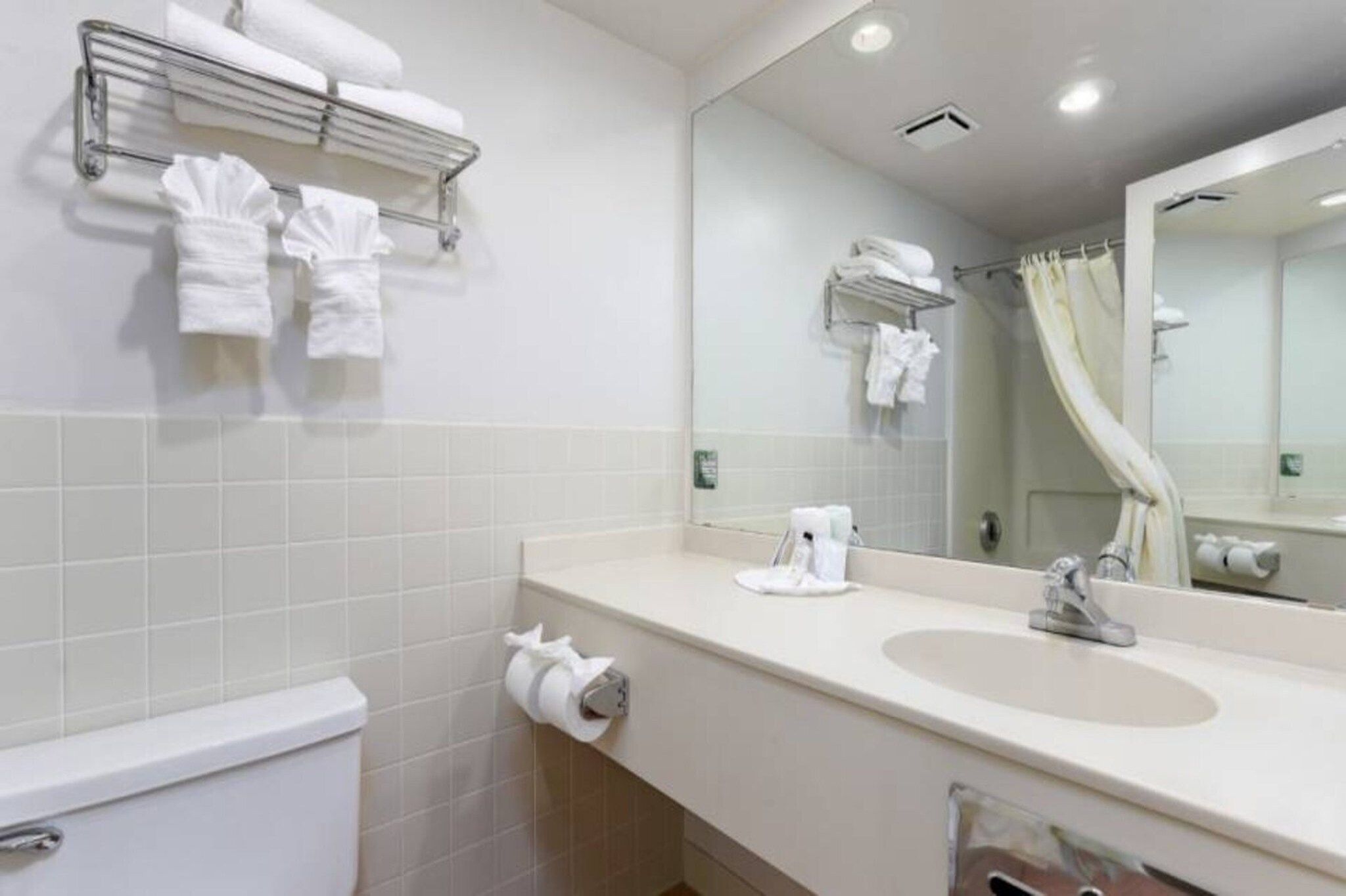 Ein Hotelbad mit Toilette, Waschbecken und Handtuchhalter.