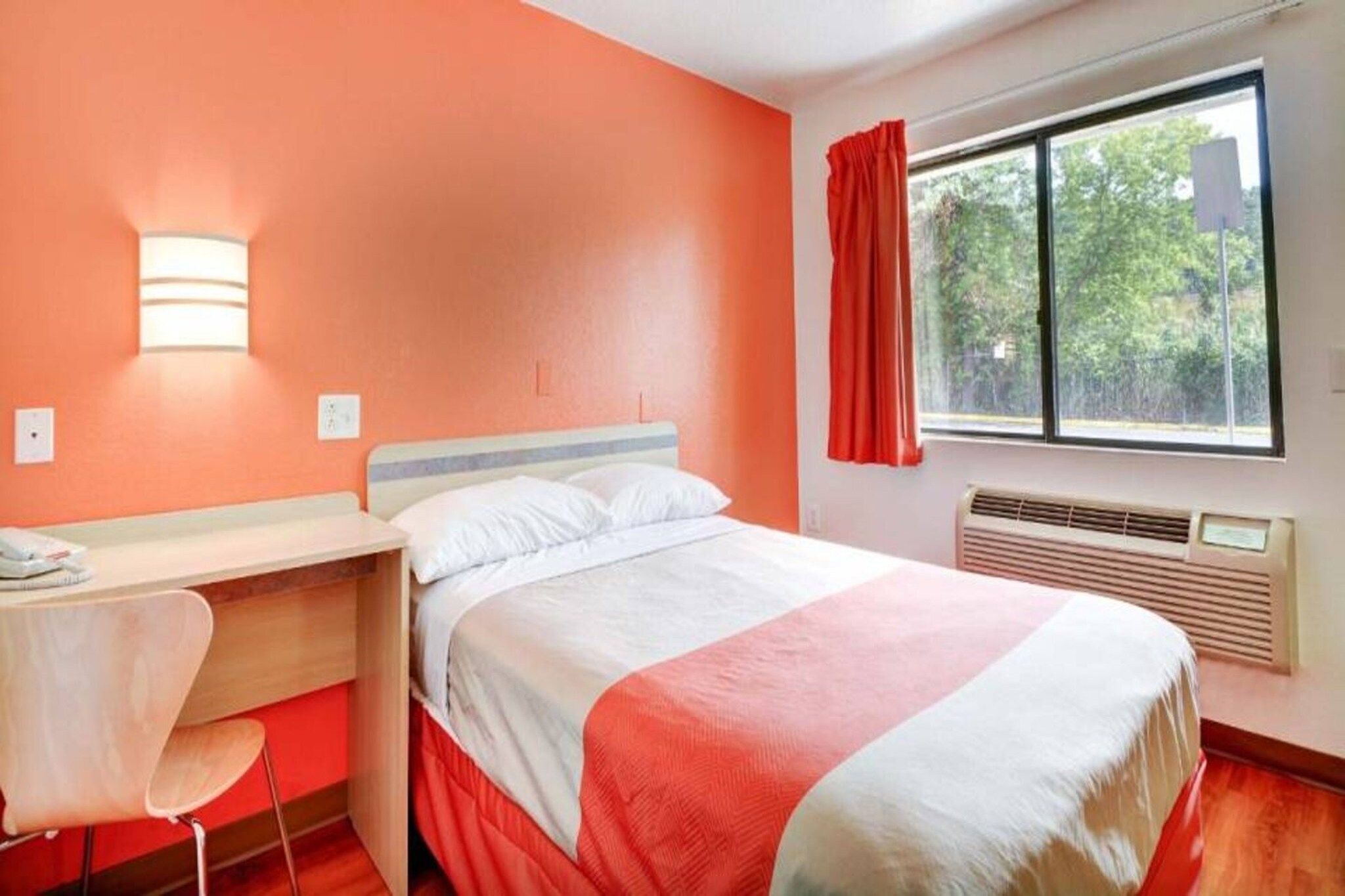 Ein Hotelzimmer mit einem Bett, einem Schreibtisch und einem Stuhl.