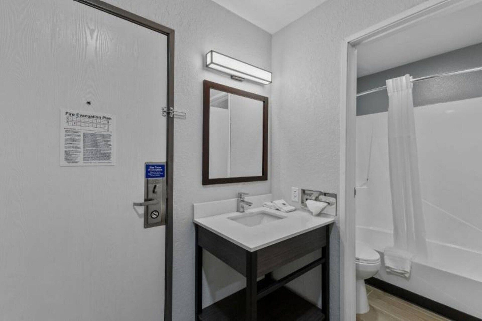 A bathroom with a sink, mirror, and shower curtain.