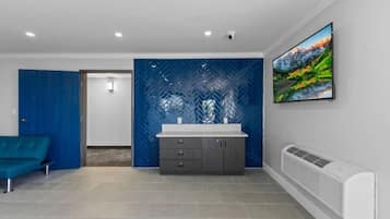 A modern bathroom with a large mirror, a sink, and a shower area.