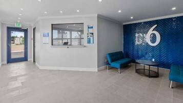 A reception area with a blue wall, a large number '6', and a window overlooking a parking area.