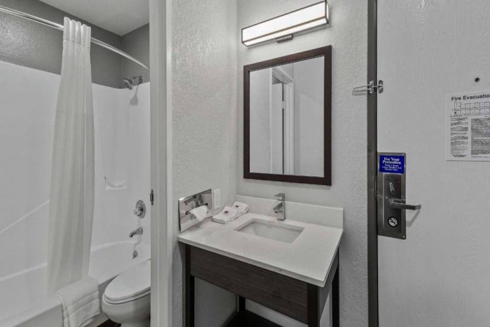 Une salle de bain équipée d’une douche, de toilettes, d’un lavabo et d’un miroir.