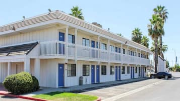 Un motel composé d’un bâtiment à deux étages, de plusieurs chambres et d’un parking.