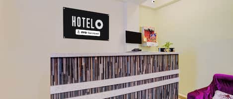 Un mostrador de recepción de hotel con un letrero que dice 'HOTELO' y 'YOY-Serviced'.