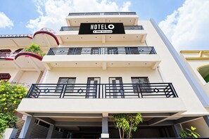 Un edificio de hotel de varios pisos con un letrero que indica que es administrado por Oyo.