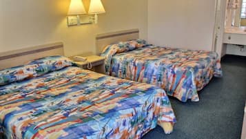 Ein Hotelzimmer mit zwei Betten, jeweils mit bunter Blumenbettwäsche, einem Nachttisch mit Telefon und Wandlampen.