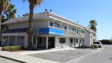 A two-story building with a 'WELCOME' sign, a covered entrance, and a parking lot.