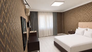 Une chambre d’hôtel avec un grand lit, un bureau, une chaise, une armoire et un téléviseur.