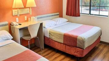A hotel room with two beds, a desk, and a chair.