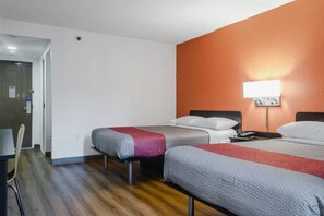 A hotel room with two beds, a desk, and a chair.