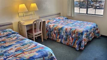 A hotel room with two beds, a desk, a chair, and a window with a view of the outside.