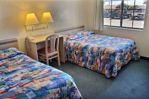 A hotel room with two beds, a desk, a chair, and a window with a view of the outside. - 2 Queen Beds | Mini Fridge (Coalinga CA)