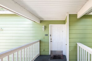 A green exterior with a white door, a mailbox, and a small porch with a white railing. - 3BR Kissimmee Condo Near Disney, Pool & Tennis (Kissimmee)