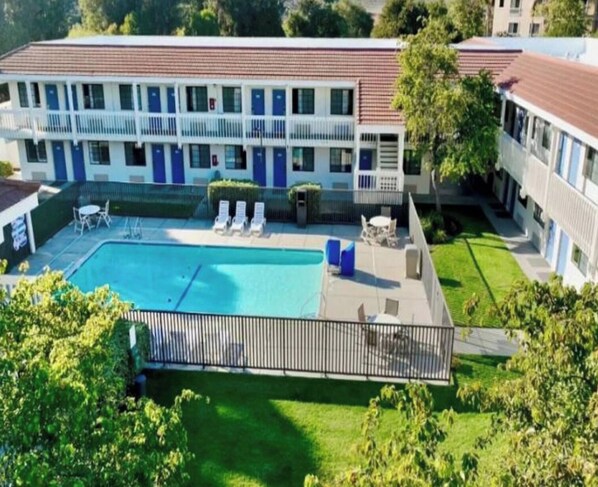 Een motel met een zwembad, buitenplaatsen en een omheind gebied.