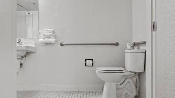 A bathroom with a toilet, a sink, and a towel rack.