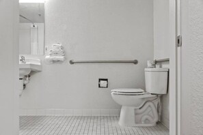 Een badkamer met toilet, wastafel en een handdoekhouder.