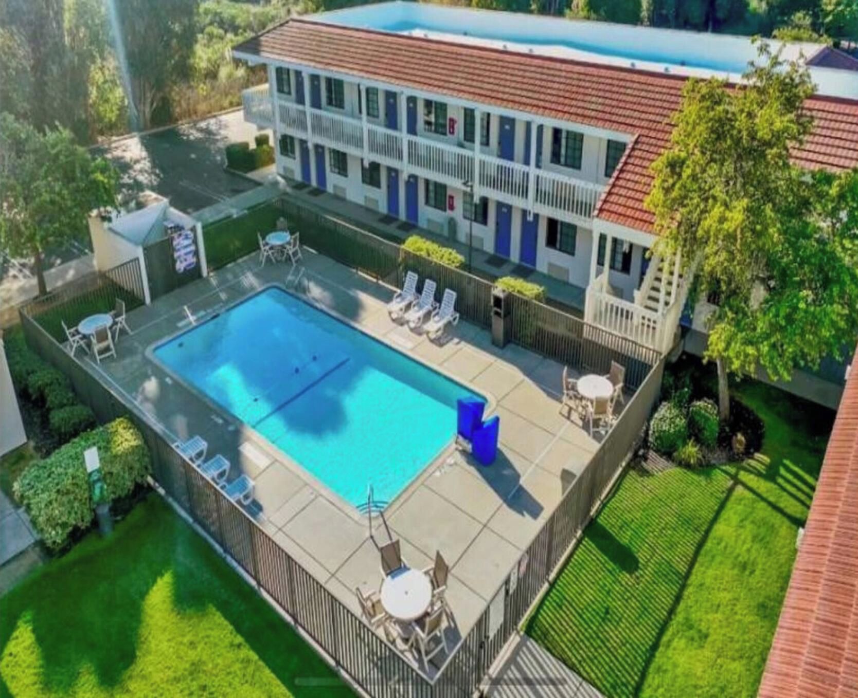 Ein Hotel mit Swimmingpool, Außenbereich und umzäunter Terrasse.