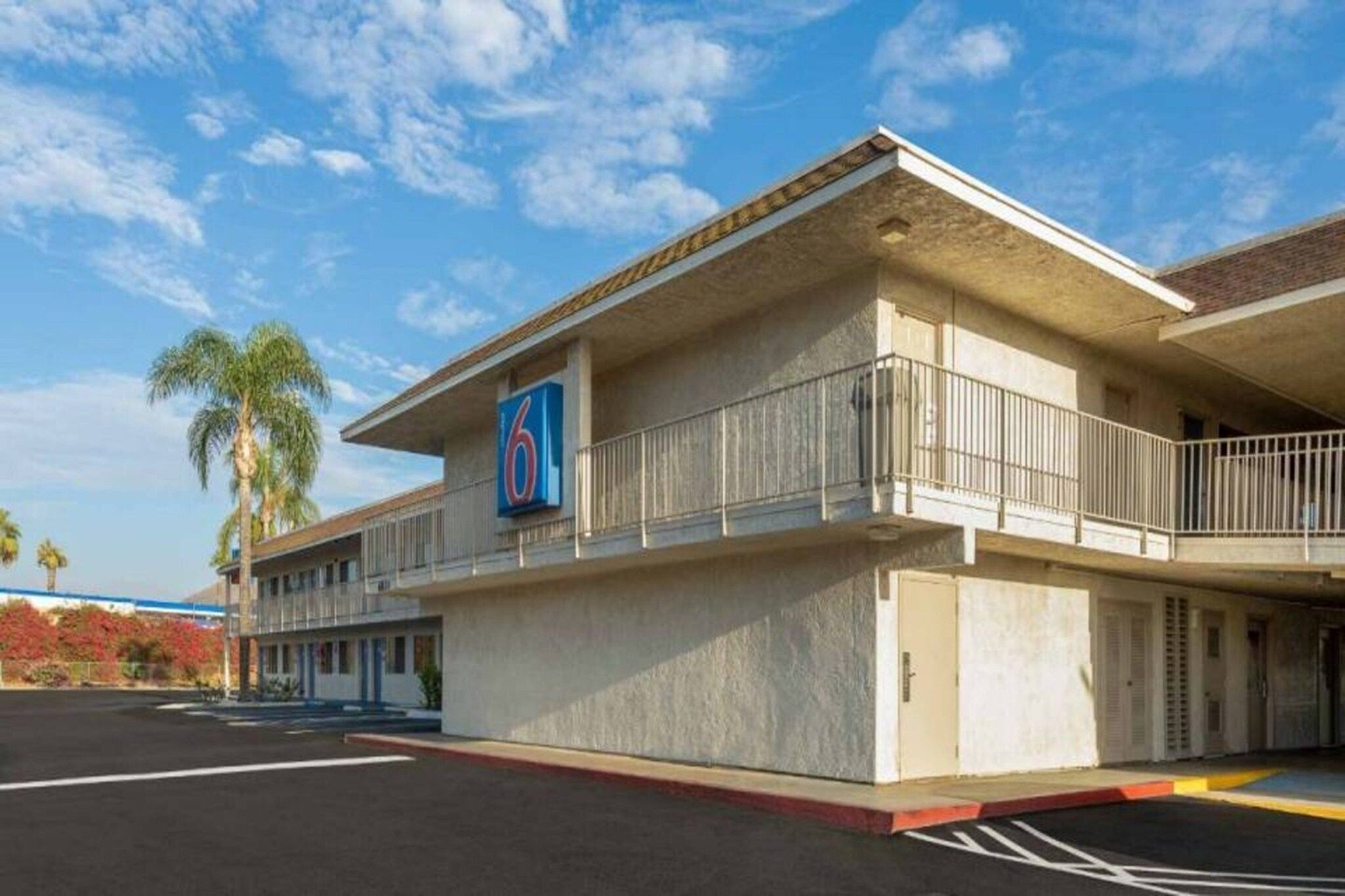 Un motel reconnaissable à son grand panneau indiquant le chiffre « 6 », doté d’un parking couvert et constitué d’un seul bâtiment.