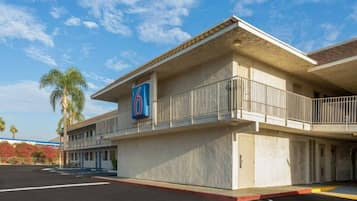A motel with a prominent '6' sign, a covered parking area, and a single-story structure.