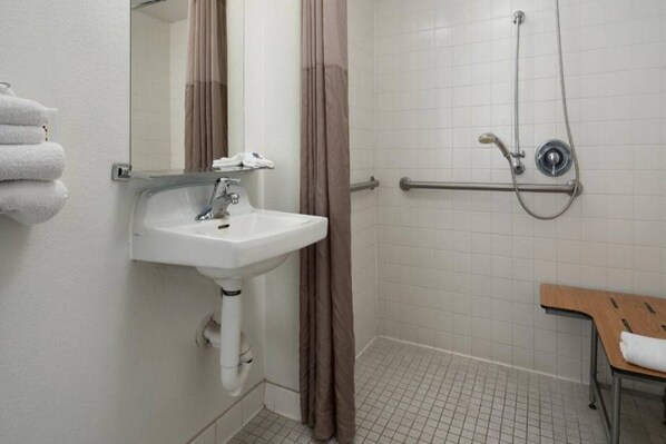 A bathroom with a sink, a shower, and a bench. - Motel 6 Pismo Beach, Ca_2 Full Beds | Ns (Pismo Beach)