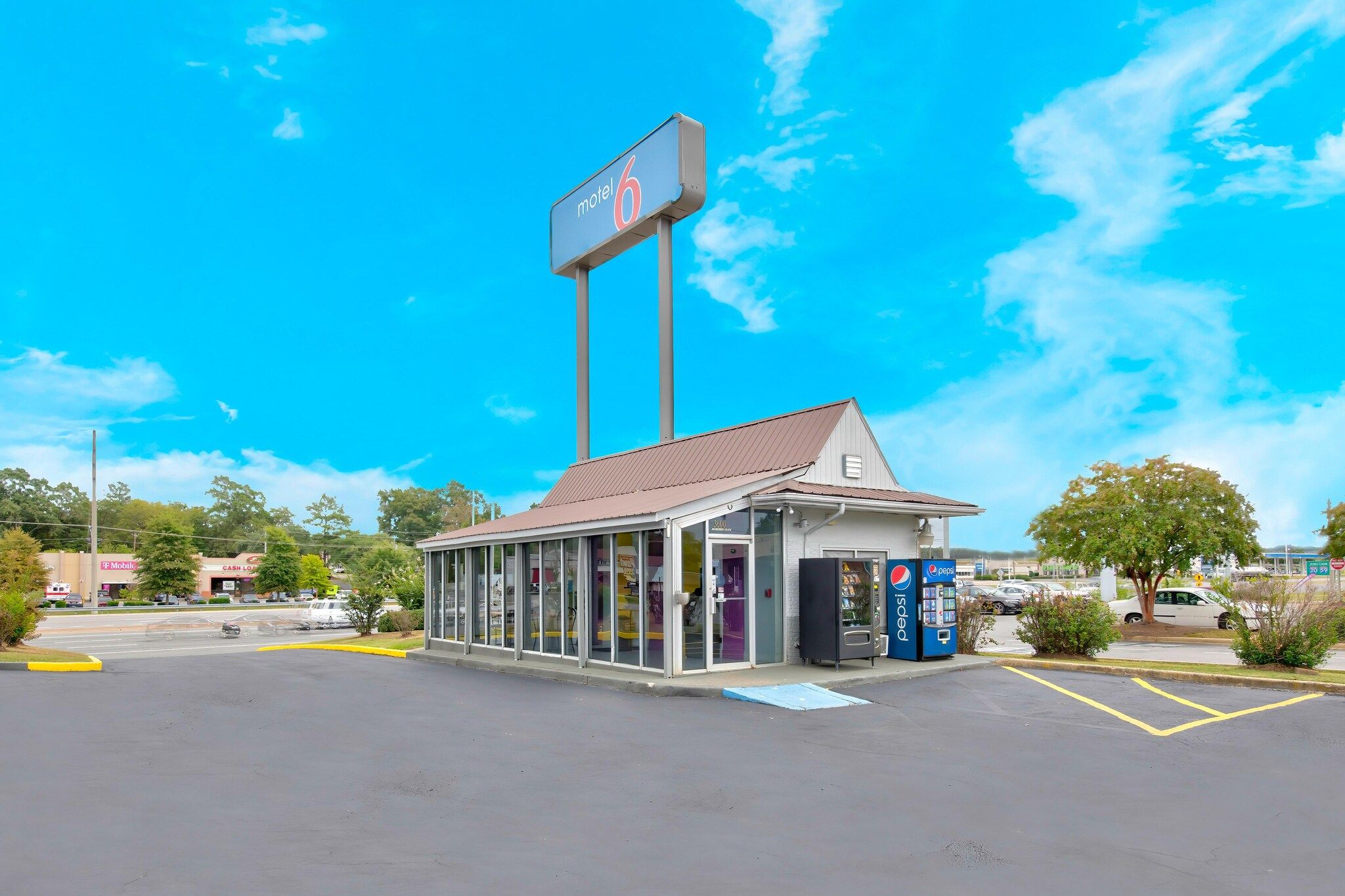 A motel with a large sign, a drive-through window, and a Pepsi vending machine.