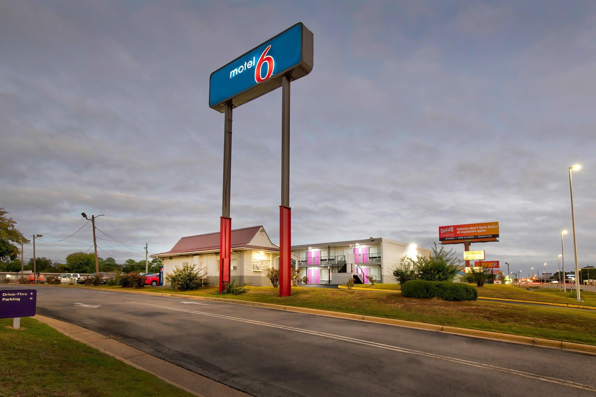 A motel with a prominent sign, a drive-thru, and a parking area.