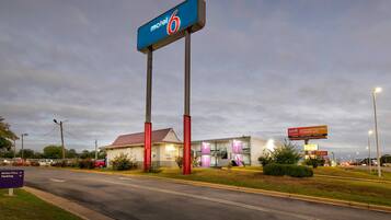 A motel with a prominent sign, a drive-thru, and a parking area.
