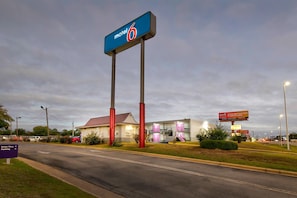 A motel with a prominent sign, a drive-thru, and a parking area. - 2 Full Beds | Non-Smoking (Tuscaloosa)
