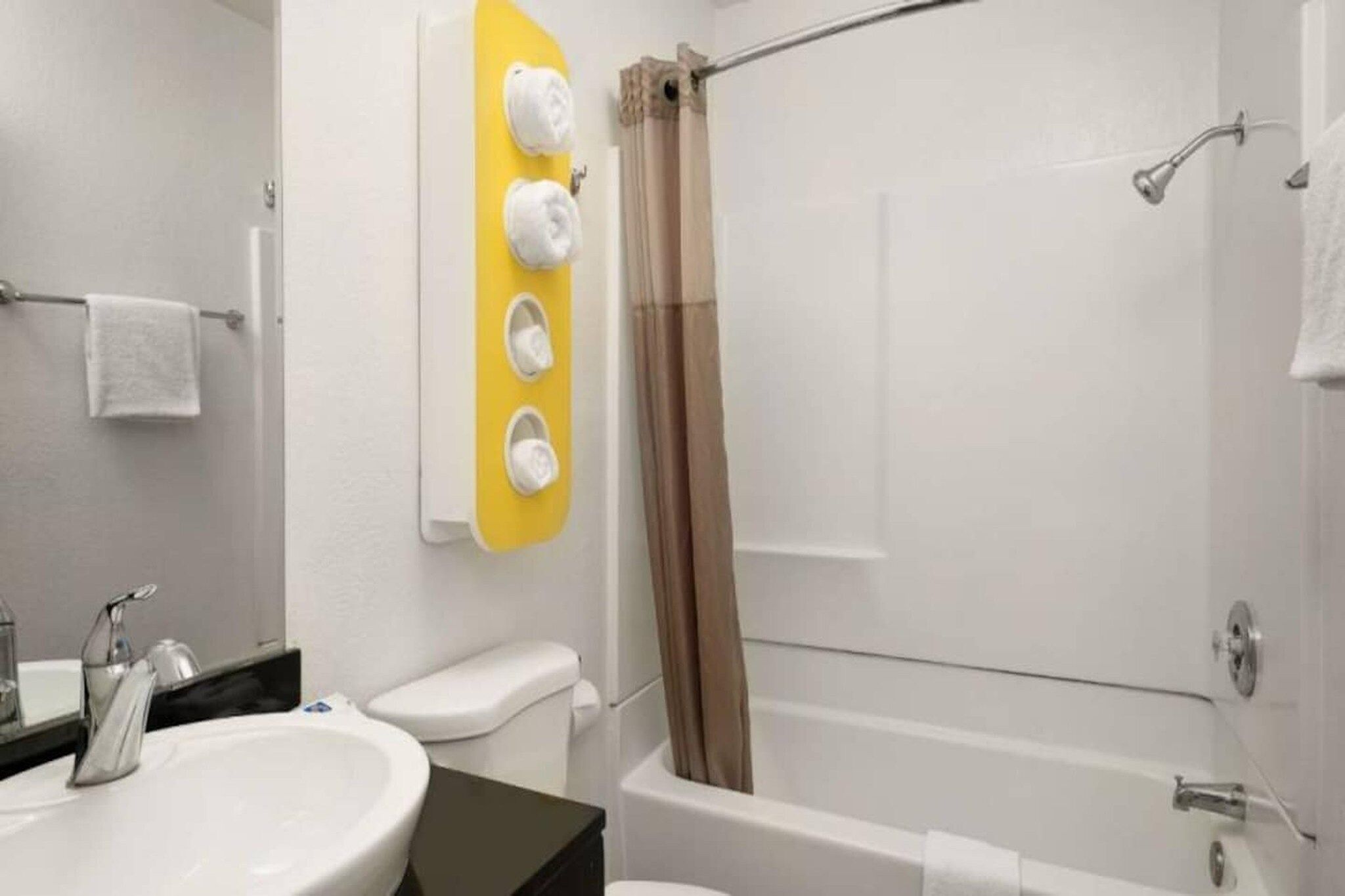 A bathroom with a bathtub, a toilet, a sink, and a mirror.
