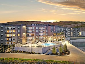 A multi-story hotel with balconies, a swimming pool, and a restaurant.
