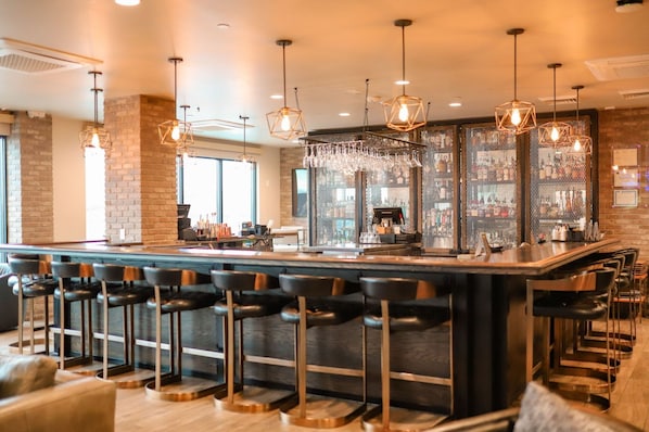 Een bar met verschillende zitmogelijkheden, waaronder barstoelen en een hoge bar.