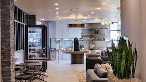 Een modern interieur met een eethoek, een open haard en een zithoek met een bank en een grote plant.
