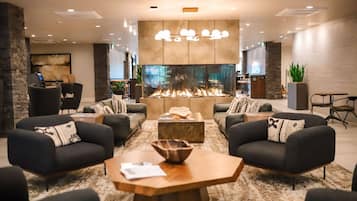 A modern lounge area with sofas, a coffee table, and a fireplace.