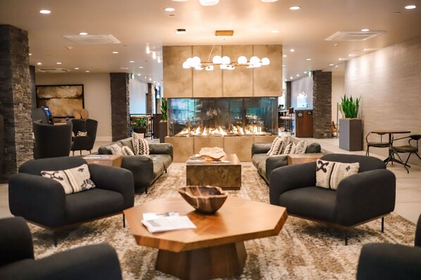 Un'area lounge moderna con divani, un tavolino da caffè e un caminetto.