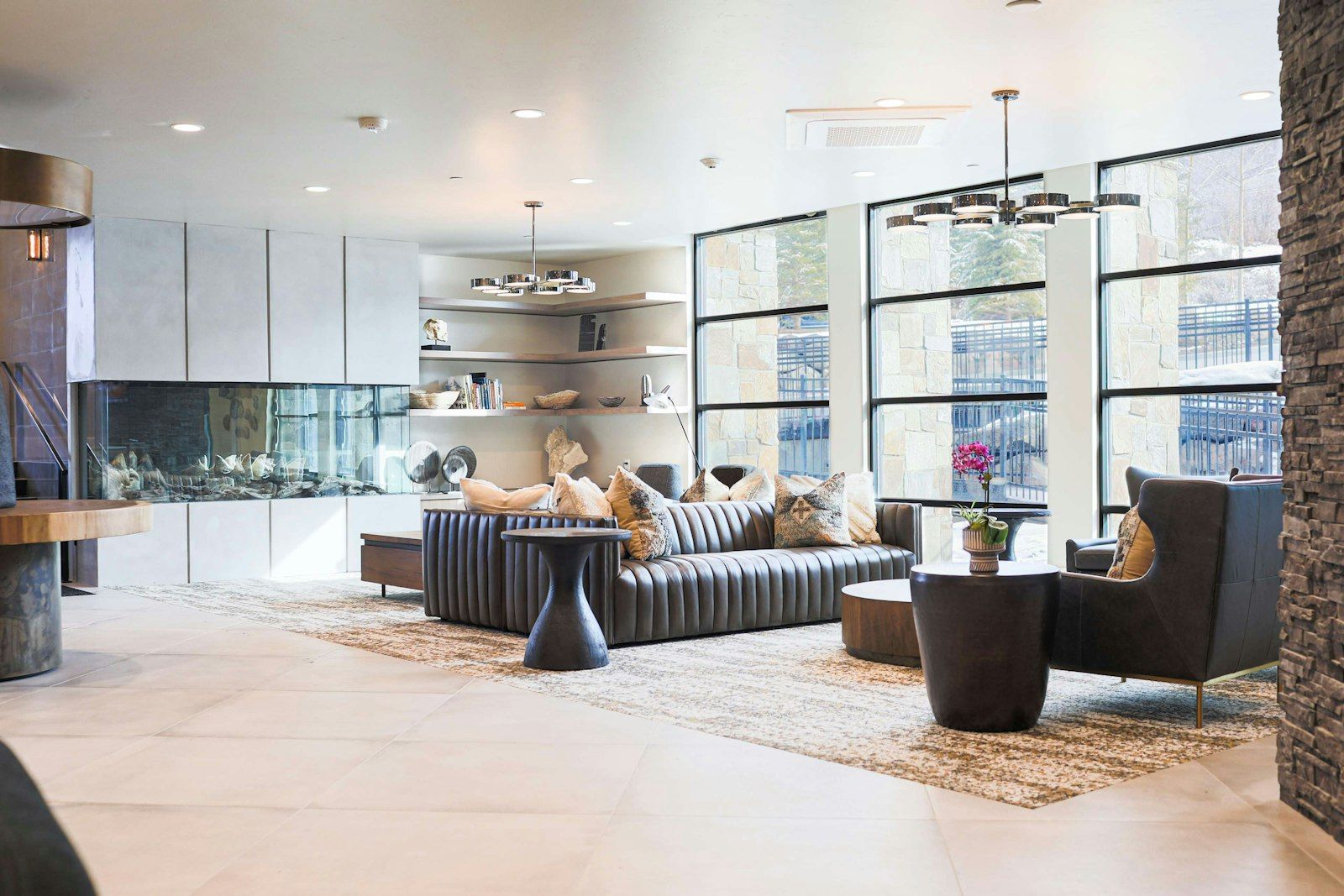 A modern living room with a sofa, chairs, a coffee table, and a fireplace.