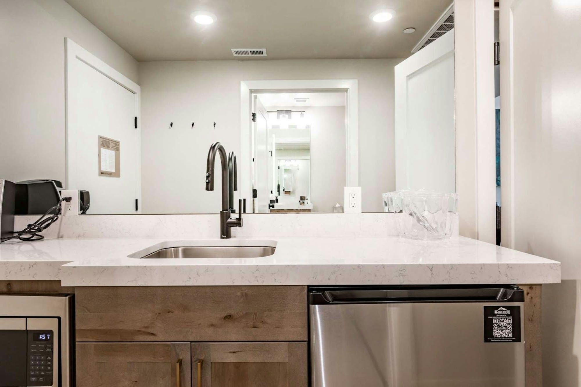 A modern kitchen with a stainless steel dishwasher, a built-in oven, and a microwave.