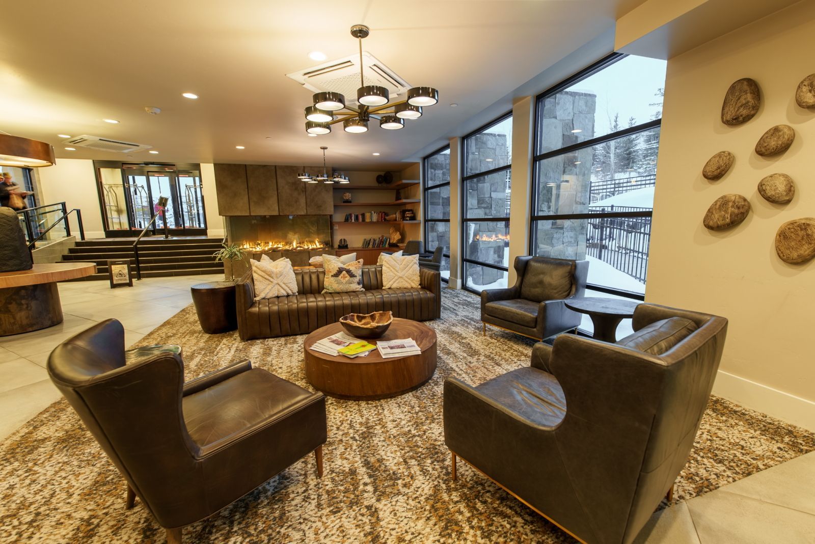 A modern living room with leather sofas, a coffee table, and a fireplace.