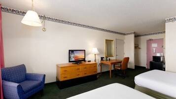 A hotel room with two beds, a desk, a chair, a dresser, a television, and a lamp.