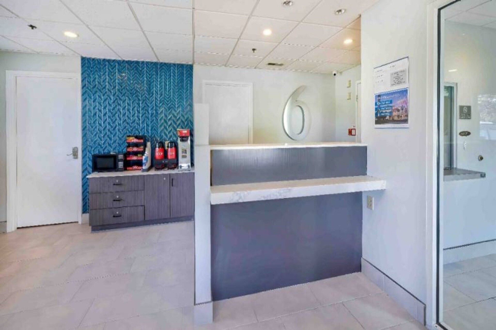A reception area with a counter, a blue patterned wall, and a door.