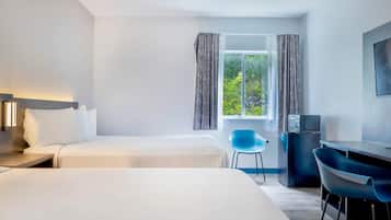 Een hotelkamer met twee bedden, een bureau, een stoel en een televisie.