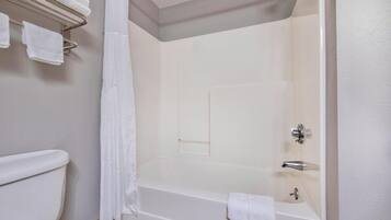 A bathroom with a bathtub, toilet, and towel rack.