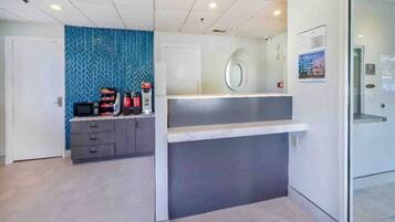 A reception area with a counter, a blue patterned wall, and a door.