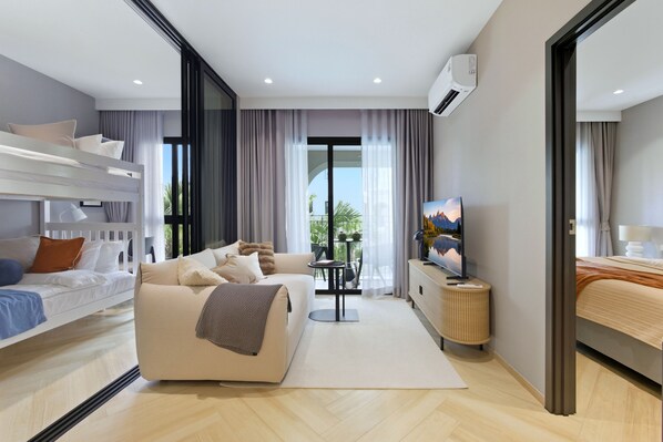 Une chambre d’hôtel moderne équipée d’un canapé, d’une télévision, d’un balcon et d’un lit.