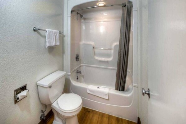 Ein Badezimmer mit Toilette, Badewanne und Dusche.