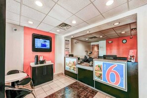 A restaurant interior with a counter, seating area, and a television screen. - Cozy 1 Queen Bed | Micfridge (East Lyme)