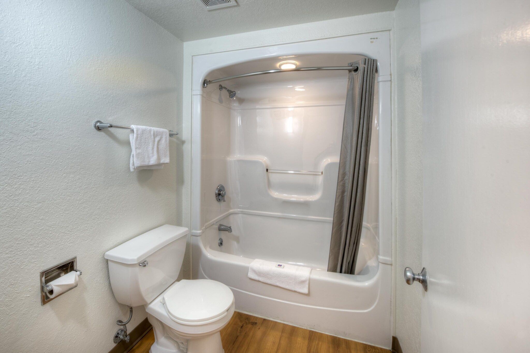 A bathroom with a toilet, a bathtub, and a shower curtain.