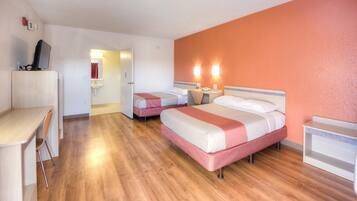 Habitación de hotel con dos camas, un escritorio y una silla.