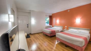 Een hotelkamer met twee bedden, een bureau en een stoel.