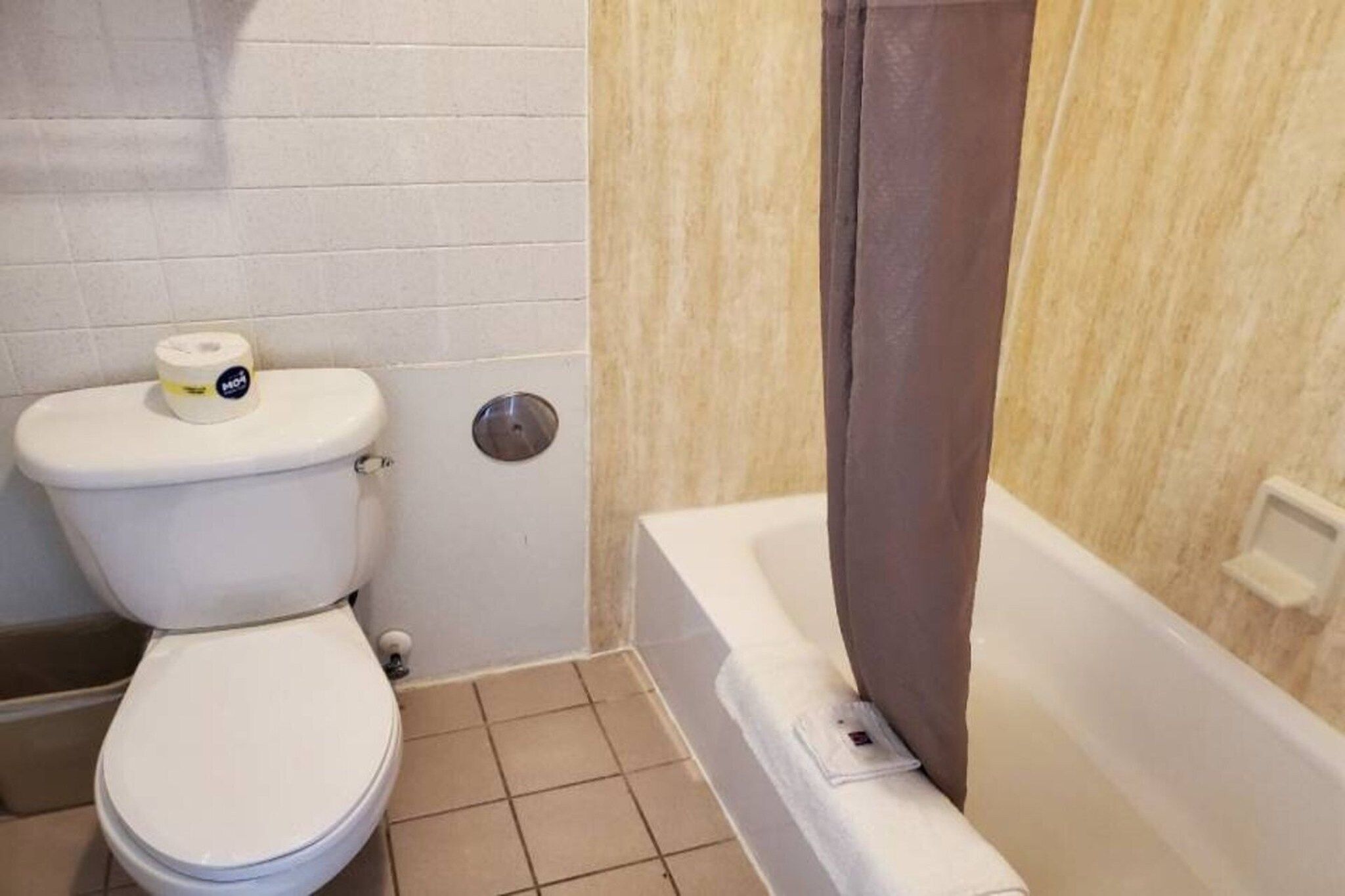 Une salle de bain avec des toilettes, une douche et une baignoire.