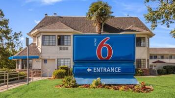 Une enseigne de motel avec le chiffre 6 et une flèche indiquant l’entrée.